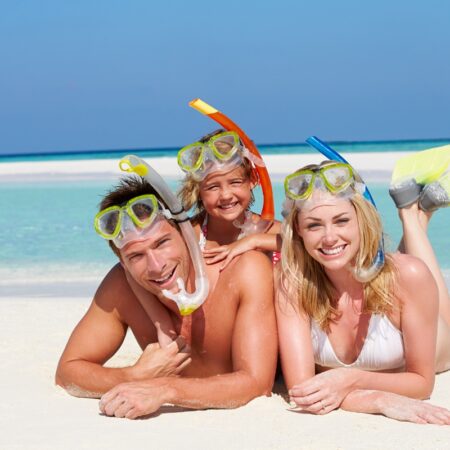 Family With Snorkels Enjoying Beach Holiday